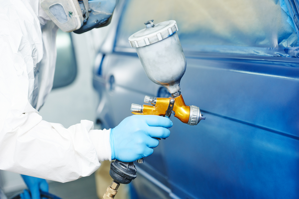 Carro em cabine de pintura recebendo nova cor em oficina especializada