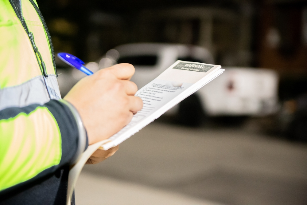 Motorista preocupado lendo notificação de multa no celular dentro do carro